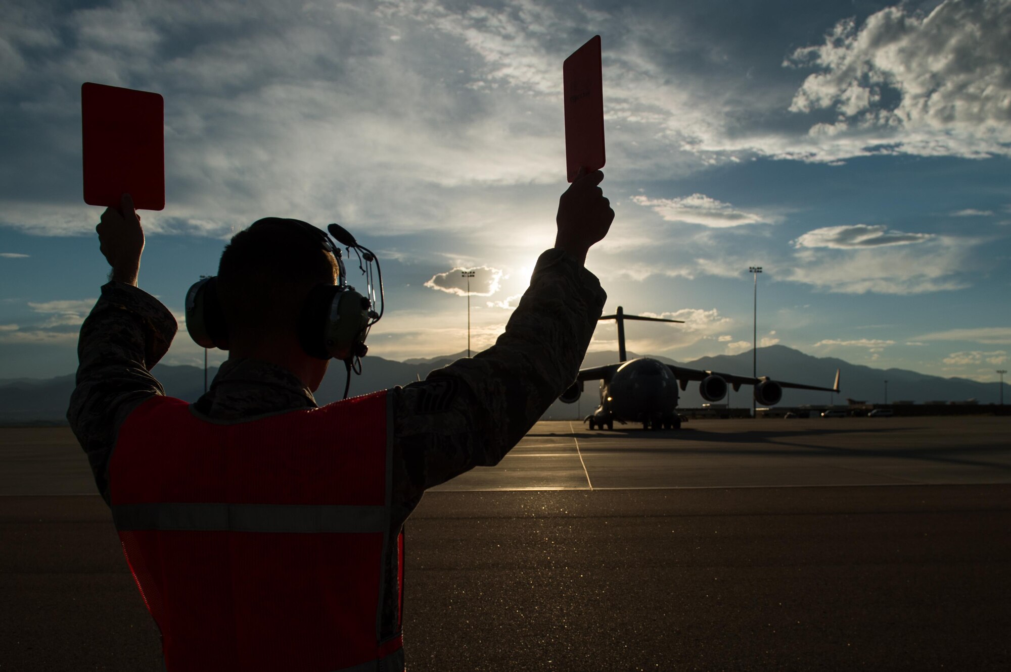 U.S. Air Force Tech. Sgt. Joshua Kasper, 821st Contingency Response Squadron aerospace maintenance supervisor, marshalls a C-17 Globemaster III aircraft during Exercise Cerberus Strike 16-02 at the Fort Carson Air Terminal, Colo., Sept. 11, 2016. C-Strike is a joint exercise where contingency response forces rehearse potential real-world situations by training with Army counterparts in cargo uploading and downloading on aircraft, aircraft engine running off-loads, communications, aerial port procedures, and air mobility liaison officer operations with airdrops from aircraft. (U.S. Air Force photo by Master Sgt. Joseph Swafford)