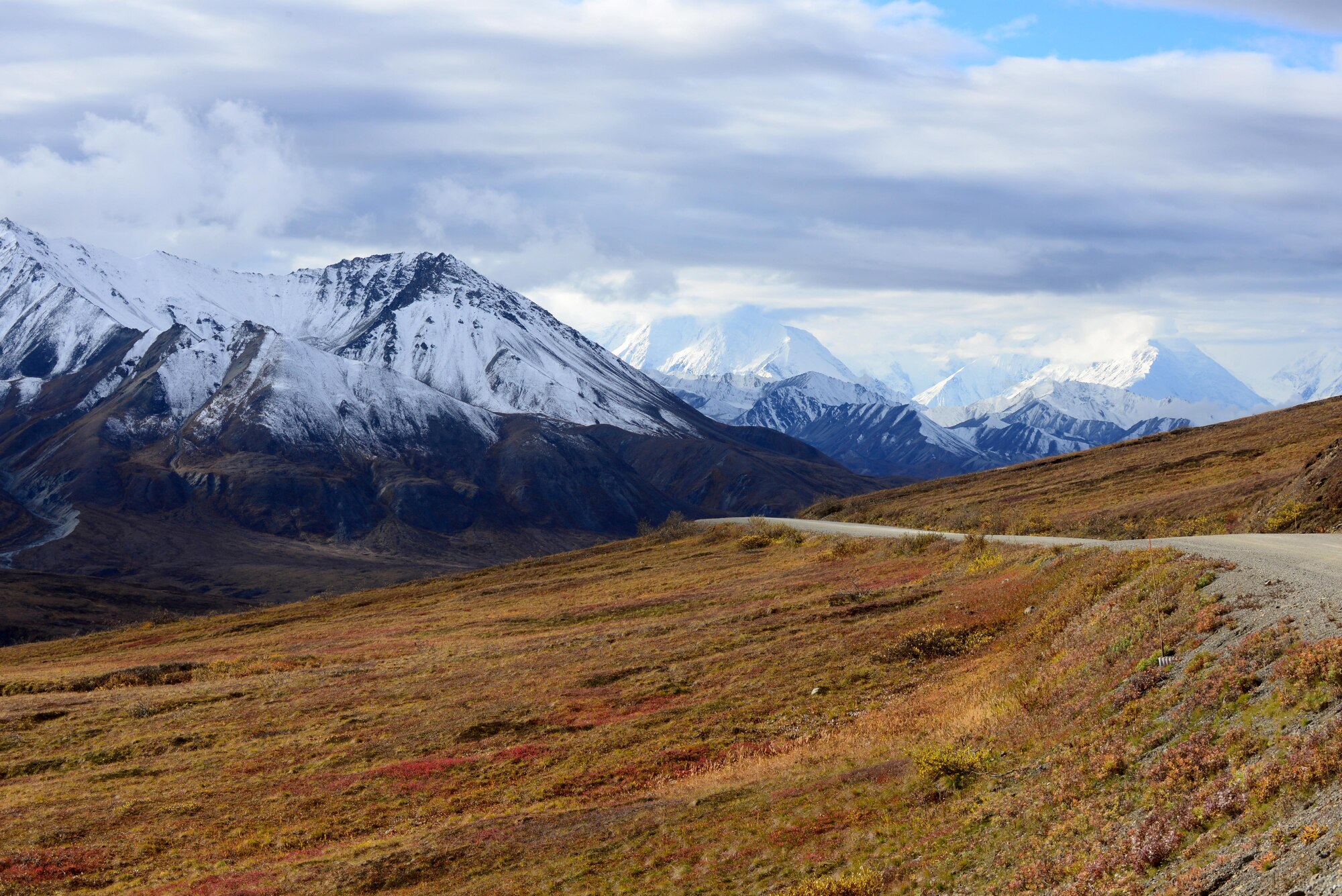 Mountains become visible through the clouds Sept. 20, 2016, in Denali National Park and Preserve, Alaska. This is only one of the many views of beautiful scenery offered on the drive through the park. (U.S. Air Force photo by Airman 1st Class Cassandra Whitman)