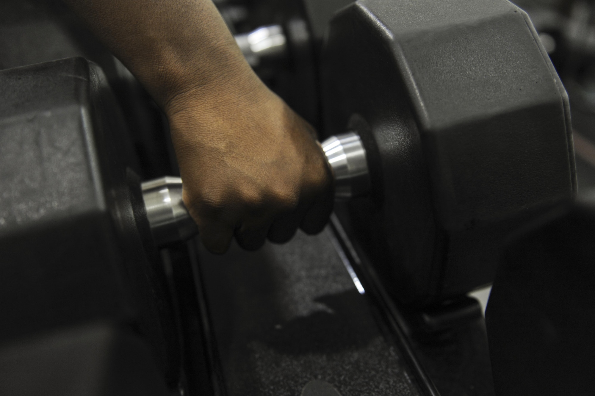 A member of the Commando Fitness Center picks up a dumbbell at Hurlburt Field, Fla., Sept. 22, 2016. The Commando Fitness Center now offers 24/7 gym access to dependents and retirees at the fitness center. (U.S. Air Force photo by Airman Dennis Spain)
