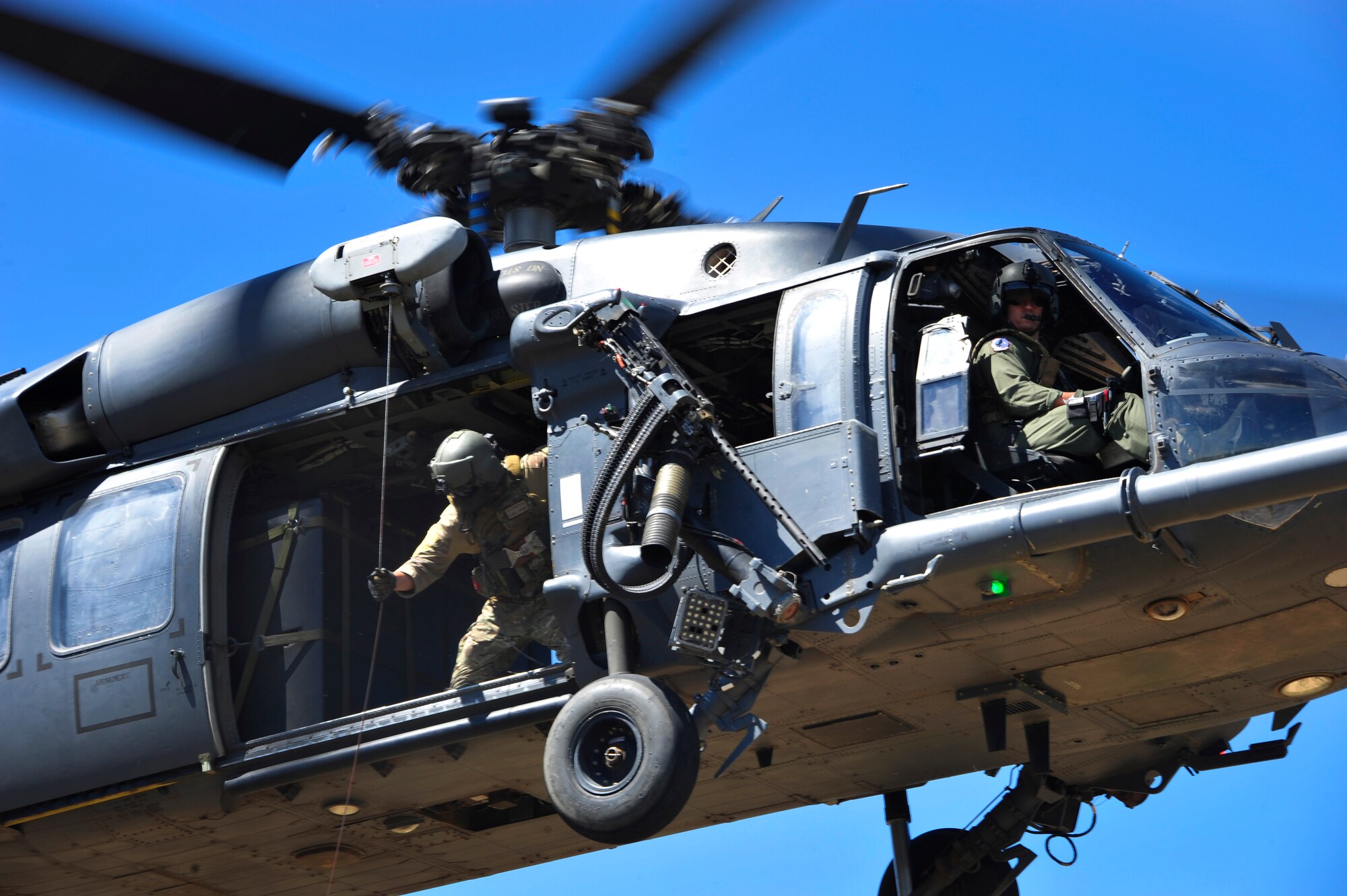 Members from the 55th Rescue Squadron hoist a simulated down pilot off the ground into an HH-60G Pave Hawk during a search and rescue exercise at Outlaw/Jackal military operations area in southeastern Ariz., Sept. 15, 2016. During the exercise, rescue assets remained in constant communication with the downed pilot to execute a successful extraction. (U.S. Air Force photo by Senior Airman Cheyenne A. Powers)