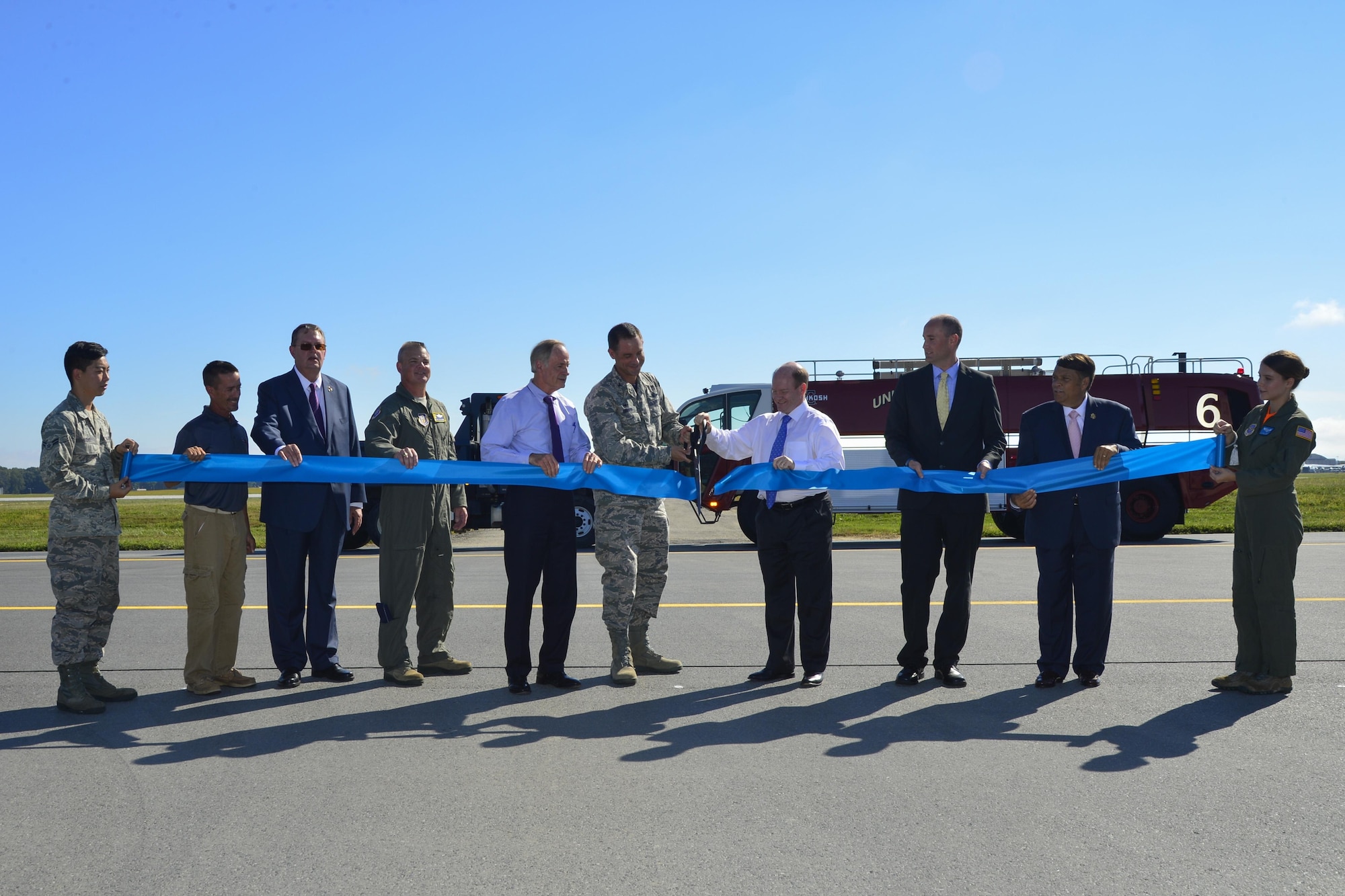 Col. Ethan Griffin, 436th Airlift Wing commander, and Sen. Chris Coons, D-Del.; cut a ribbon marking the reopening Runway 01-19 during an extensive reconstruction project Sept. 23, 2016, at Dover Air Force Base, Del. Shown from left, Airman 1st Class Joseph Cho, 436th Aircraft Maintenance Squadron; Tony Price, sub-contractor representative; Jeff Wagonhurst, Versar Inc. president and CEO; Col. Scott Durham, 512th AW commander; Sen. Tom Carper, D-Del.; Col. Ethan Griffin, 436th AW commander; Sen. Chris Coons, D-Del.; Drew Slater, Rep. John Carney D-Del. representative; Robin Christiansen, Mayor of Dover; and Airman 1st Class Paula Padilla, 9th Airlift Squadron loadmaster. (U.S. Air Force photo by Senior Airman William Johnson) 