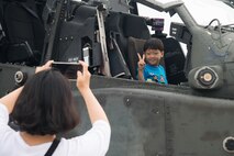 A family in attendance at Air Power Day 2016 takes a picture with an AH-64D Apache at Osan Air Base, Republic of Korea, Sept. 25, 2016. Members of Team Osan and the surrounding community participated in events for the air show such as static displays, aircraft takeoffs and aerial demonstrations. (U.S. Air Force photo by Senior Airman Dillian Bamman)