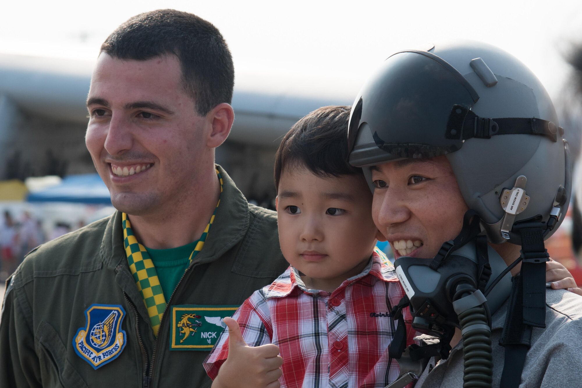 U.S. Air Force 1st Lt. Nick Castle, 25th Fighter Squadron pilot, poses for a photo with a family during Air Power Day 2016 at Osan Air Base, Republic of Korea, Sept. 24, 2016. The air show highlighted performances of many different aircraft including the Republic of Korea air force Black Eagles. (U.S. Air Force photo by Senior Airman Dillian Bamman)