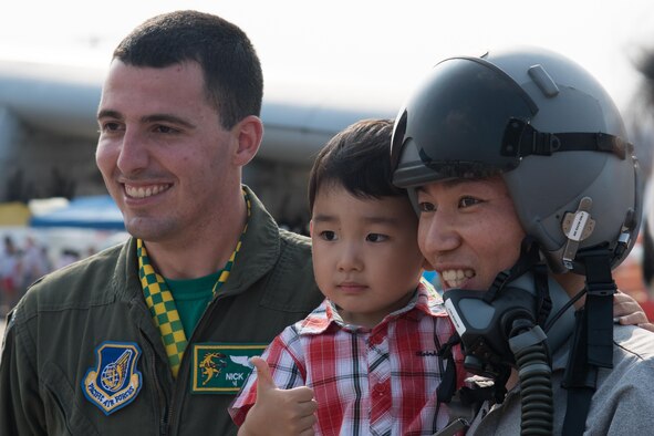 U.S. Air Force 1st Lt. Nick Castle, 25th Fighter Squadron pilot, poses for a photo with a family during Air Power Day 2016 at Osan Air Base, Republic of Korea, Sept. 24, 2016. The air show highlighted performances of many different aircraft including the Republic of Korea air force Black Eagles. (U.S. Air Force photo by Senior Airman Dillian Bamman)