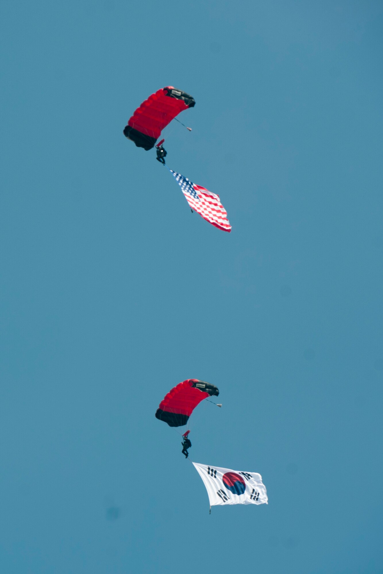 U.S. and Republic of Korea flags sail through the sky attached to a Republic of Korea Parachute Demonstration Team parachutist during Air Power Day 2016 on Osan Air Base, Republic of Korea, Sept. 24, 2016. Air Power Day was a chance for U.S. and Korean attendees to get to know one another while watching aerial demonstrations, entertainment and more. (U.S. Air Force photo by Staff Sgt. Jonathan Steffen)