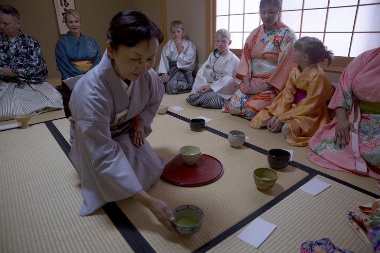 An instructor from the Yayoi Kimono Shop and Cultural School serves matcha, a powdered green tea, to a guest during a Japanese Tea Ceremony Class Sept. 17 in Naha, Okinawa, Japan. The class provided Status of Forces Agreement personnel with the opportunity to experience Japanese traditions firsthand. During the class, instructors who hosted the event dressed the SOFA personnel in kimonos and taught them polite phrases and courtesies one must use when visiting a Japanese home. The students learned how to politely partake of tea and refreshments and how to prepare, present and serve the matcha.