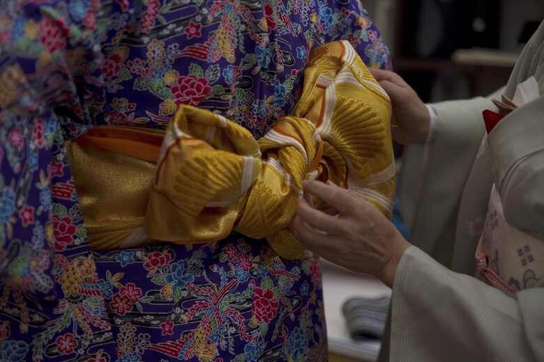 An instructor ties an obi, also known as a scarf, during a Japanese Tea Ceremony Class at the Yayoi Kimono Shop and Cultural School Sept. 17 in Naha, Okinawa, Japan. The class gave Status of Forces Agreement members the opportunity to dress in traditional Japanese garments and learn about Japanese culture firsthand. During the class, instructors who hosted the event dressed the SOFA personnel in kimonos and taught them the customs and courtesies that accompany visiting a Japanese home. The students learned how to properly receive tea and refreshments and how to prepare the matcha, which is a powdered green tea commonly served at tea ceremonies.
