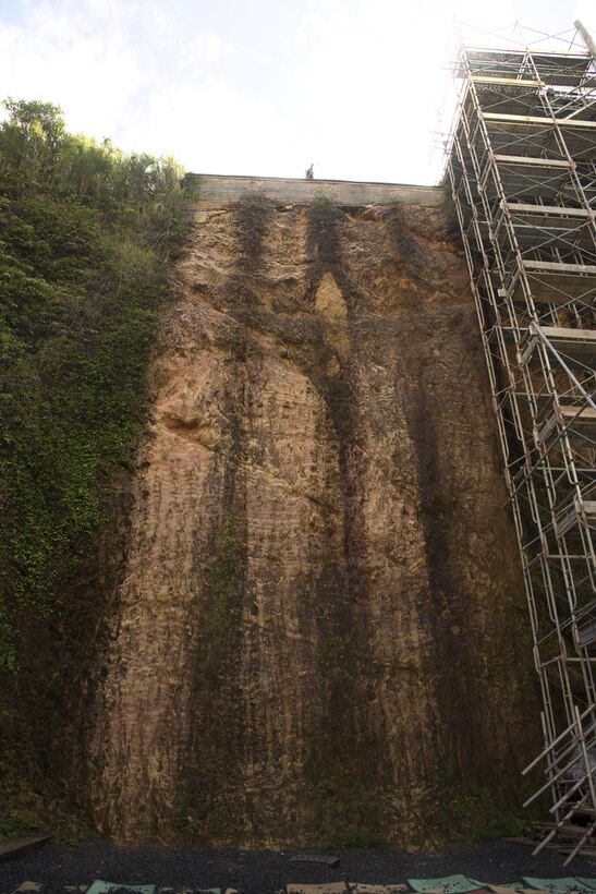 A Marine stands at the top of a cliff used for rappelling Sept. 20, 2016 at Jungle Warfare Training Center in Okinawa, Japan. The cliff is one of the many areas where Marines must demonstrate proficiency in tactical operations in the jungle environment. JWTC stretches across more than 17,000 acres and is home to several rigorous courses through which Marines must navigate harsh terrain and climate-specific training in preparation for operations in the Asia-Pacific region. 