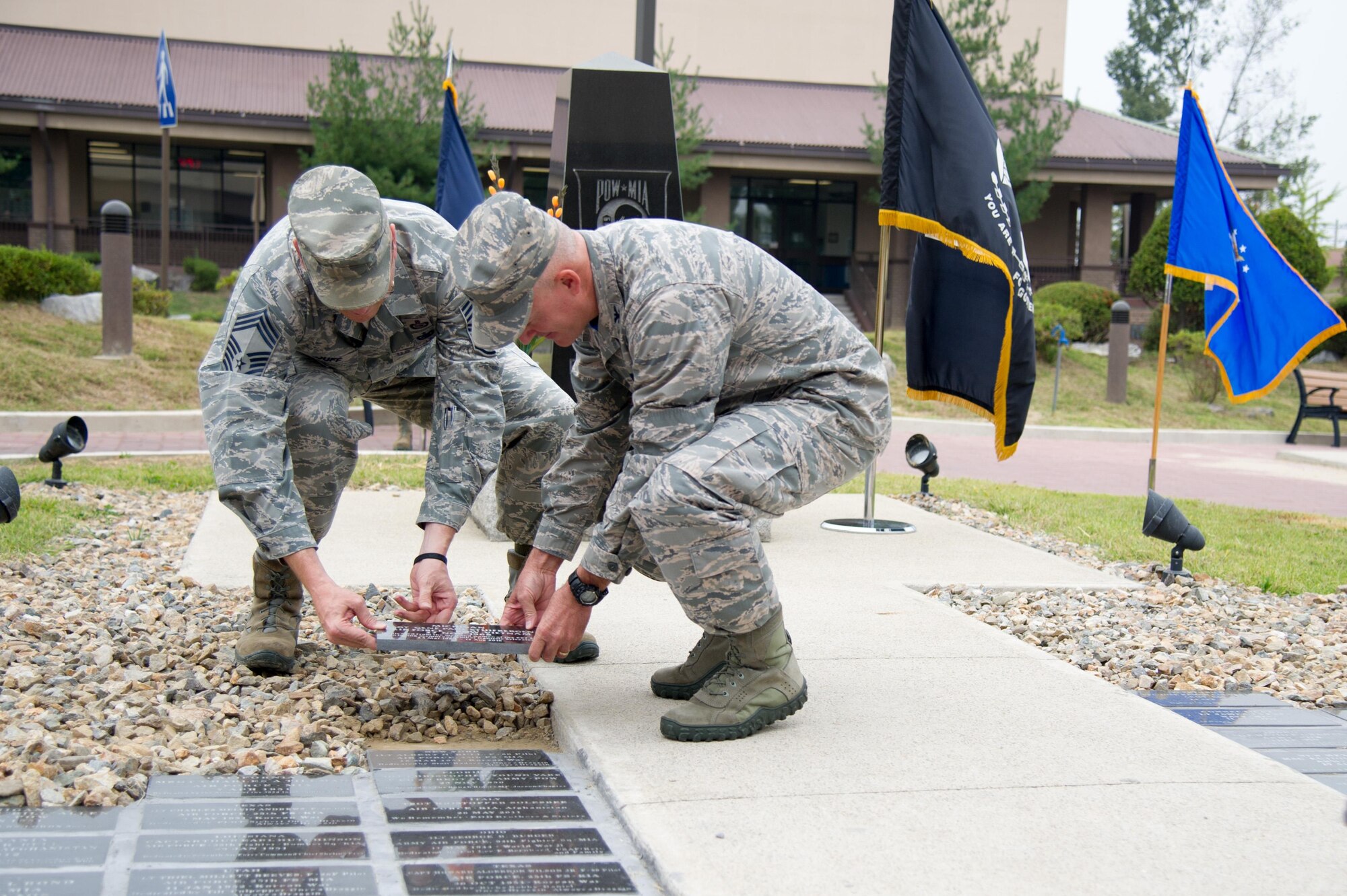 U.S. Air Force Chief Master Sgt. David Plouff, 694th Intelligence, Surveillance and Reconnaissance Group superintendent, and Col. Andrew Hansen, 51st Fighter Wing commander, place a brick bearing the name of a POW/MIA service member during a POW/MIA memorial closing ceremony at Osan Air Base, Republic of Korea, Sept. 16, 2016. The event honors missing service members and the U.S. government’s continued responsibility to locate POW/MIA. (U.S. Air Force photo by Staff Sgt. Jonathan Steffen)