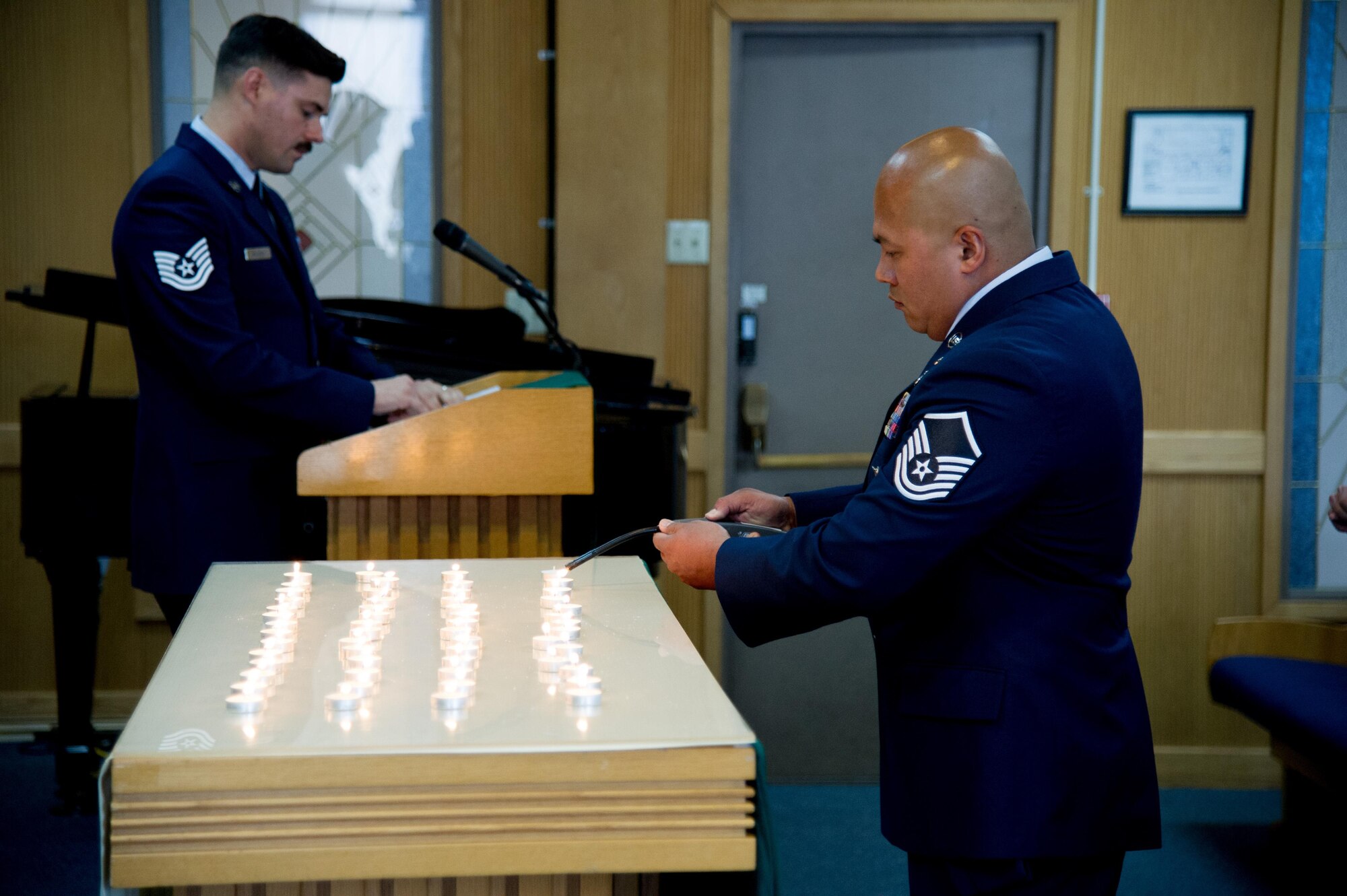 U.S. Air Force Master Sgt. Philip Quinn-Narcis, 51st Civil Engineer Squadron assistant chief of fire operations, lights a candle during a POW/MIA memorial service at Osan Air Base, Republic of Korea, Sept. 15, 2016. POW/MIA Remembrance Day is traditionally observed on the third Friday of September each year.(U.S. Air Force photo by Staff Sgt. Jonathan Steffen)