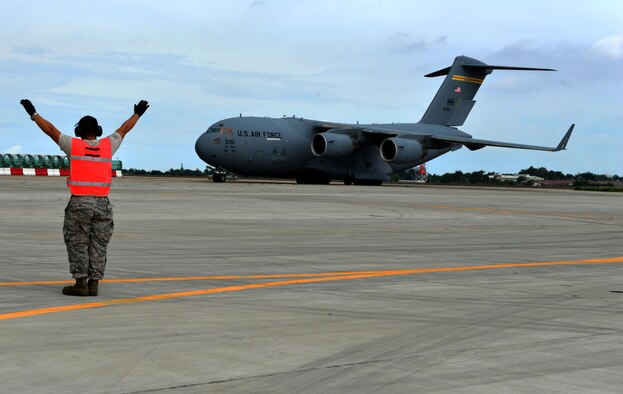 A U.S. Air Force member marshals a U.S. Air Force C-17 to its designated ramp position at Mactan Air Base, Philippines, Sept. 24, 2016. The military members were in Mactan in support of U.S. Pacific Command’s ongoing Air Contingent mission. The goal of the rotation is for Philippine military and civilian leaders to work with their U.S. counterparts to improve airlift capabilities across the spectrum of military operations and to solidify long-standing relationships in the region. (U.S. Air Force photo by Capt. Mark Lazane)