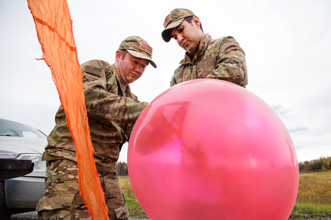Air Force Staff Sgts. Nicolas Strickler, left, and Dean Maddox prepare to launch a weather balloon while measuring climate conditions at Joint Base Elmendorf-Richardson, Alaska, Sept. 20, 2016. Strickler and Maddox are assigned to the 3rd Air Support Operations Squadron. Air Force photo by Alejandro Pena