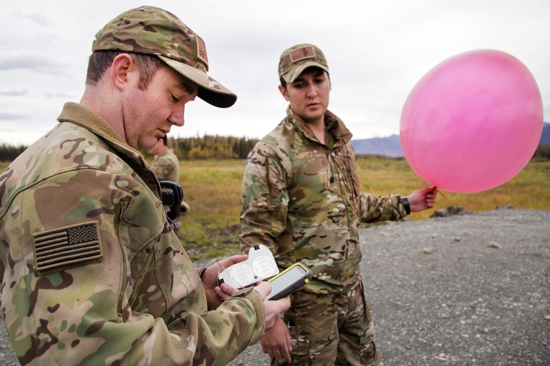 Air Force Staff Sgt. Nicolas Strickler, left, reads the metering on a gauge before Air Force Staff Sgt. Dean Maddox launches a weather balloon while measuring climate conditions at Joint Base Elmendorf-Richardson, Alaska, Sept. 20, 2016. Strickler and Maddox are assigned to the 3rd Air Support Operations Squadron. Air Force photo by Alejandro Pena