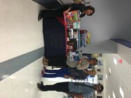Staff of the Armed Forces Bank stand in front of a National Preparedness Month 2016 display featuring items for an emergency kit. Courtesy photo by MCAS Yuma