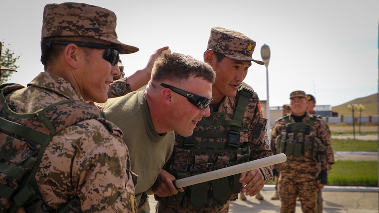 Mongolian Armed Forces soldiers escort U.S. Marine Cpl. Phillip Miller during a simulated riot for the Non-Lethal Executive Seminar 2016 at the Five Hills Training Area, Mongolia, Sept. 19, 2016. Miller is a military police Marine with 3rd Law Enforcement Battalion, III Marine Expeditionary Force. Mongolian soldiers and National Police rehearsed various riot control formations. Non-lethal weapons are designed to incapacitate equipment and personnel while minimizing fatalities and permanent injury to personnel, and undesired collateral damage to property.