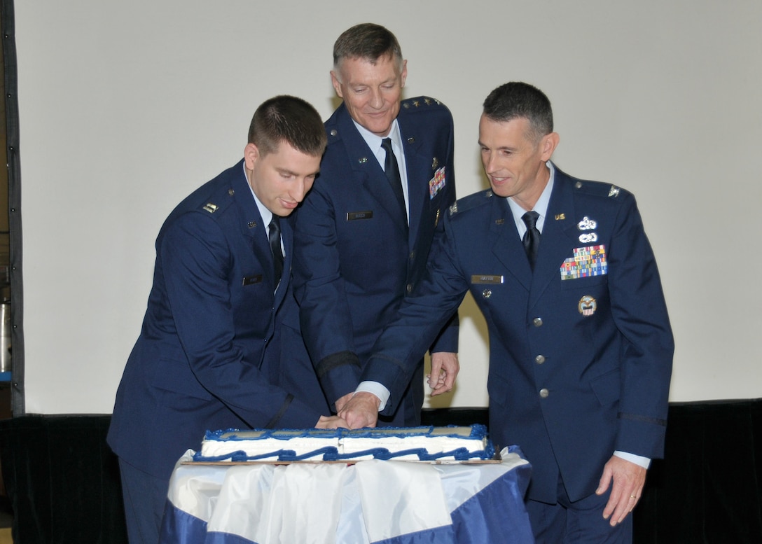 DLA Director Lt. Gen. Andy Busch (center); Capt. Shane Perry (left), the youngest airmen attending; and Col. John Martin, the oldest airman attending as a guest, use a sword to cut the Air Force birthday cake at a Sept. 22 celebration.