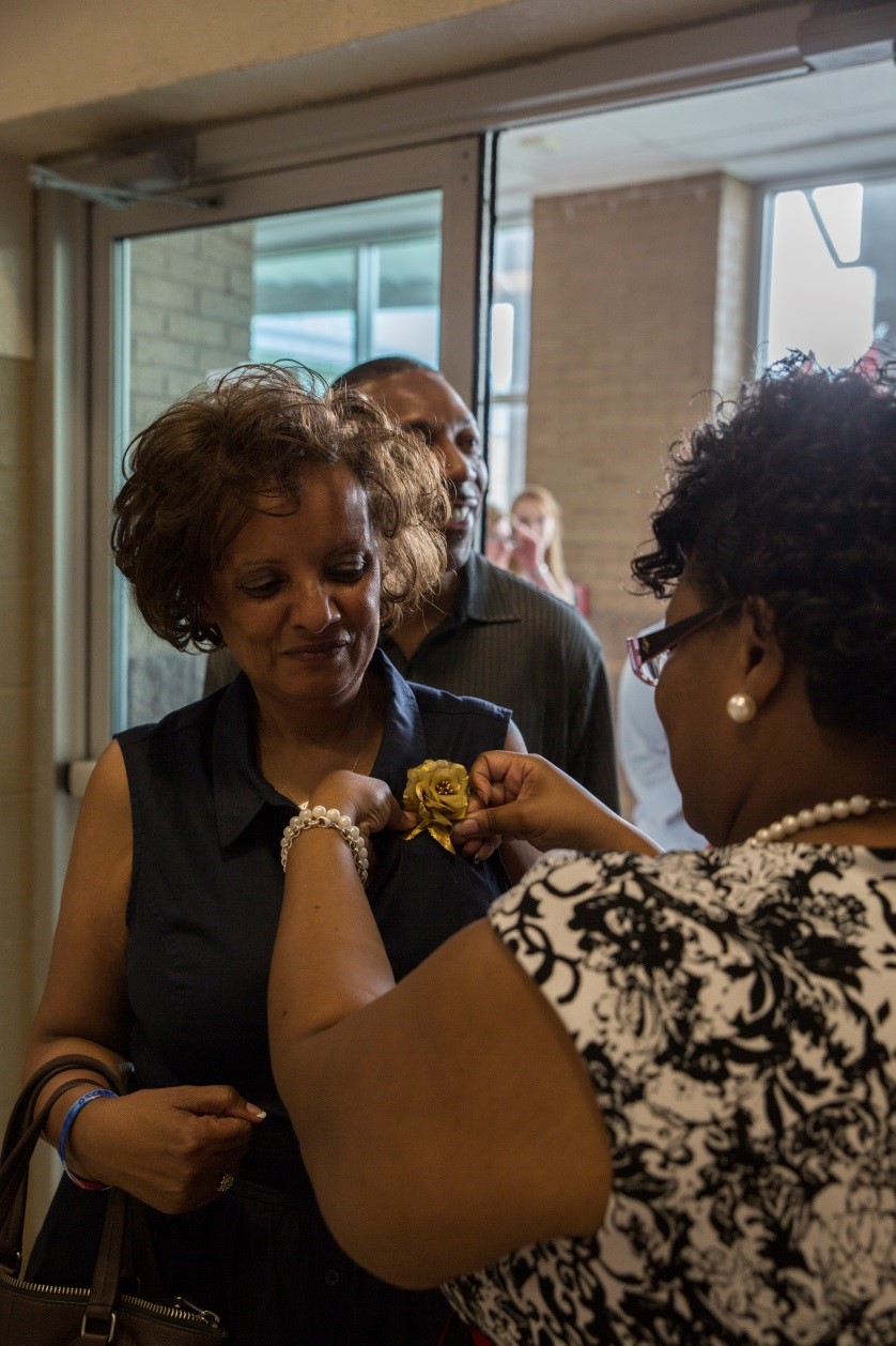 Latrise Davis, the Naval Air Station Joint Reserve Base New Orleans survivor outreach services support coordinator, pins a gold rose on Gold Star Mother Dawn Collins during the Gold Star Mothers and Family Day celebration at NAS JRB New Orleans, Sept. 25, 2016. The Gold Star families gathered to share stories and honor their loved ones who have died in service to the nation. (U.S. Marine Corps photo by Cpl. Melissa Martens/ Released)
