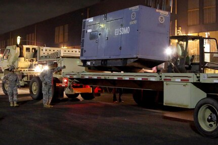 Soldiers with the Puerto Rico Army National Guard stand by as a generator is loaded on their semi-truck. Soldiers from the Puerto Rico Army Guard assisted with distributing generators trhoughout the island in the wake of power outages that have affected 1.5 million families.