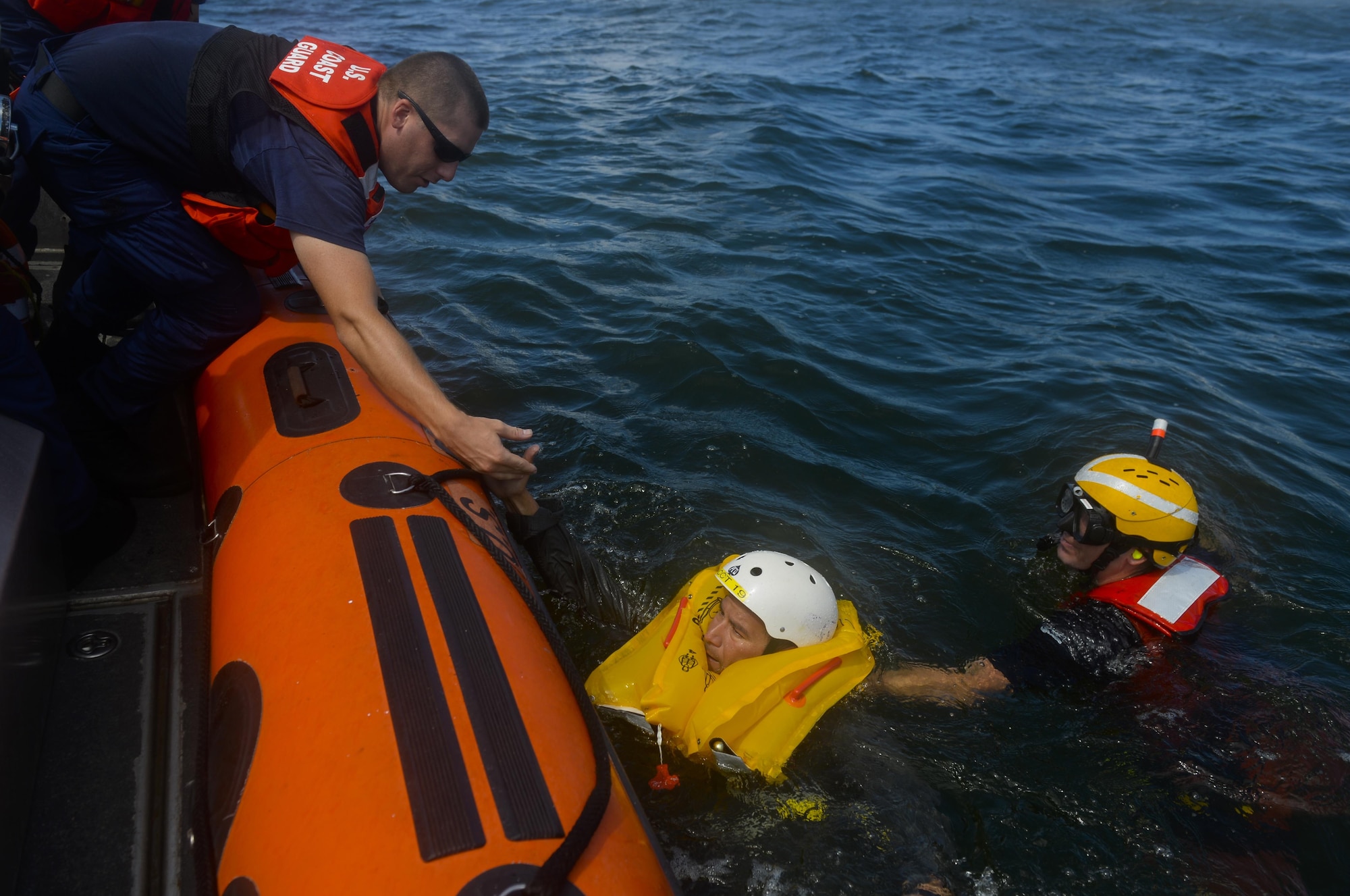 U.S. Coast Guard Sector/Air Station Corpus Christi assists a 433rd Airlift Wing pilot during water survival training Sept. 17, 2016, in the Gulf of Mexico. Pilots and aircrew personnel spent the day learning techniques they will need after egressing from an aircraft, such as donning life vests, using MK 12 and MK 13 Day/Night ignition flares and getting into a 25-manned life raft and hoisted from a Life Preserver Unit to a hovering MH-65 Dolphin helicopter. (U.S. Air Force photo/Staff Sgt. Matthew Fredericks)