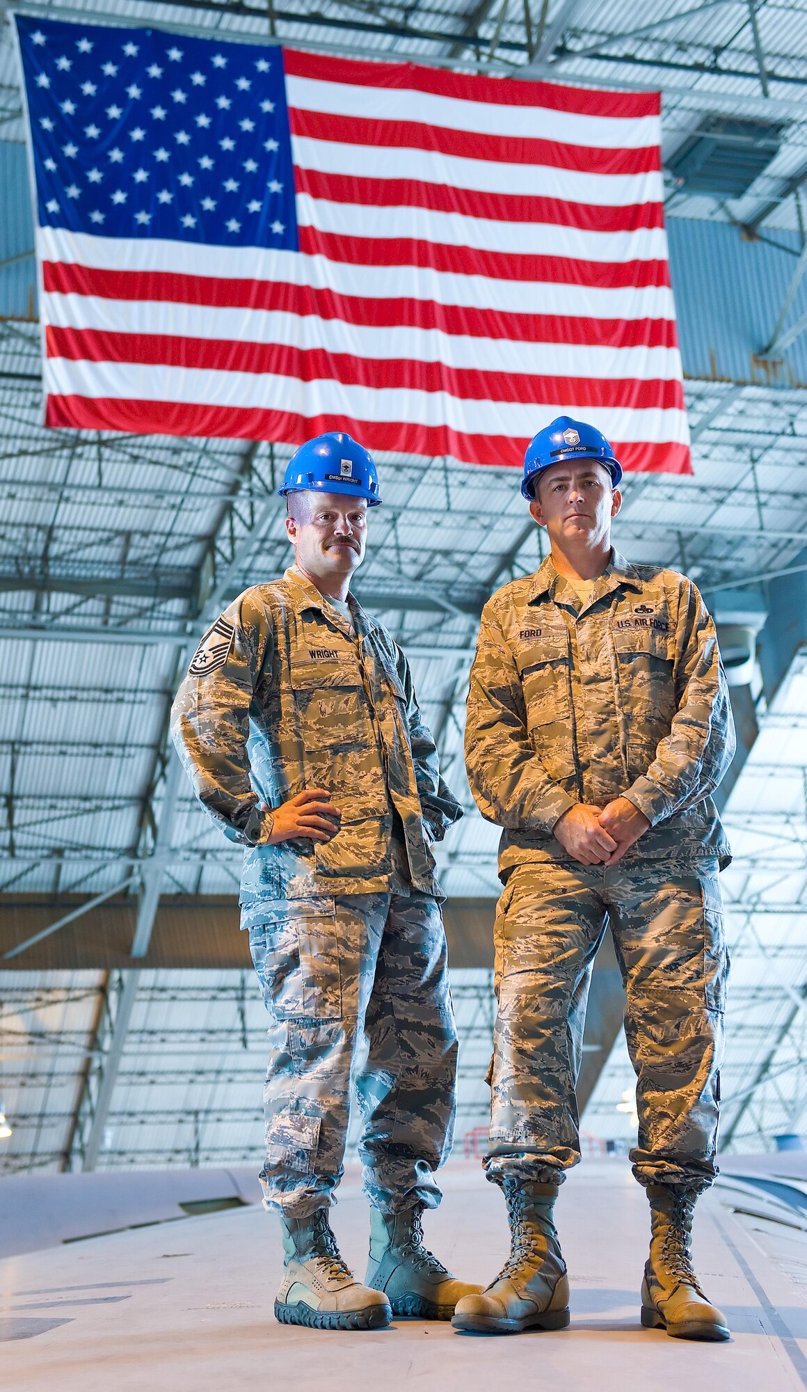 Chief Master Sgts. Robert Wright (left), 436th Maintenance Group, and Bryan Ford, 512th Maintenance Group, stand on the wing of a C-5 Galaxy aircraft July 3, 2013, inside the Isochronal Inspection Dock, Dover Air Force Base, Del. The two chiefs hail from the same hometown in Virginia and have led mirroring career paths in support of the Air Force and Air Force Reserve. Wright retired in 2014 but still works on base repairing aircraft simulators. (U.S. Air Force photo/Roland Balik)