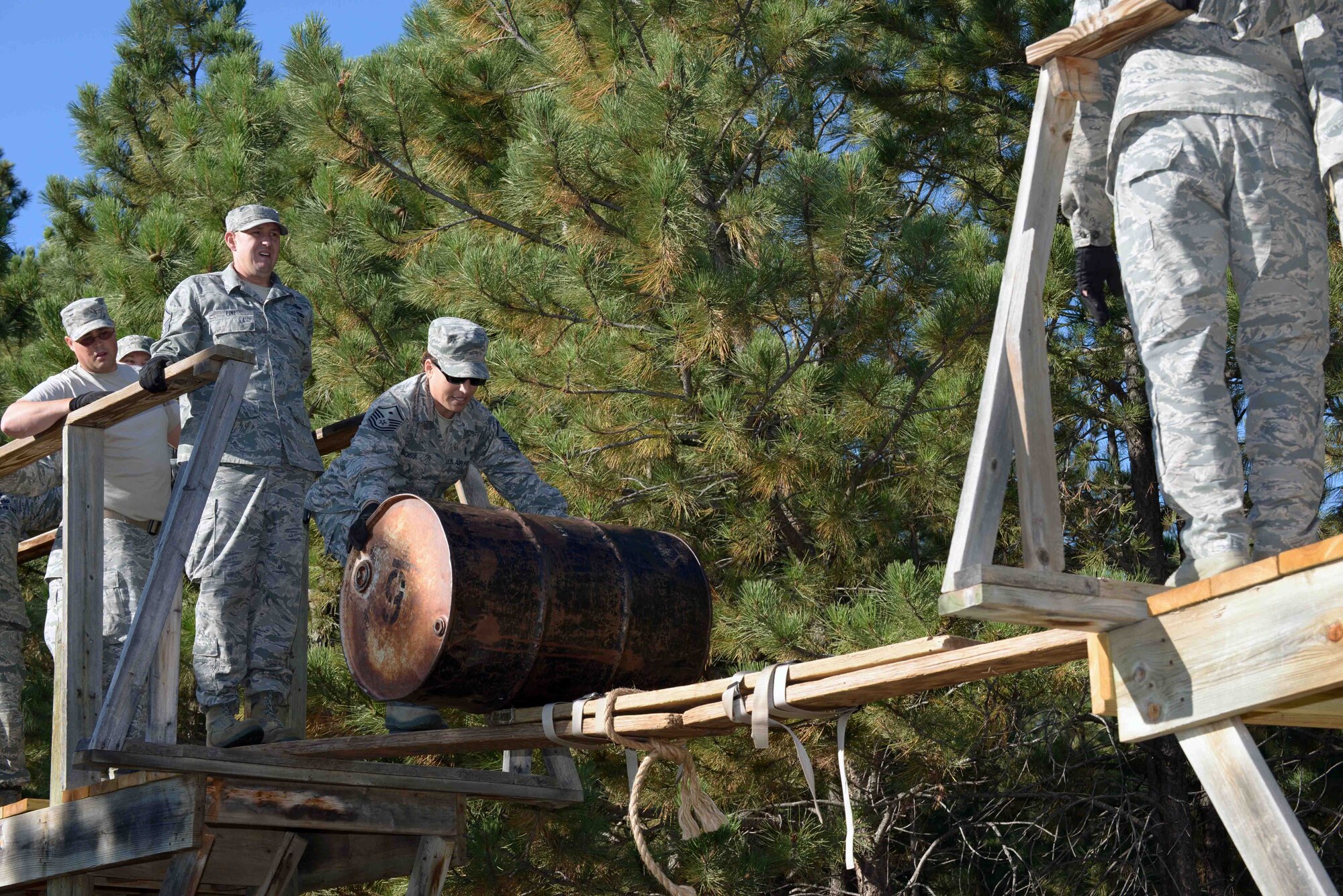 Master Sgt. Kellie Boisse, the first sergeant assigned to the 28th Logistics Readiness Squadron, rolls a barrel across a makeshift bridge during a Leadership Reaction Course at the South Dakota National Guard West Camp Rapid training facility, Rapid City, S.D., Sept. 15, 2016. Some challenges required the participants to not only get themselves across, but also retrieve the gear they utilized. (U.S. Air Force photo by Airman 1st Class Donald C. Knechtel)