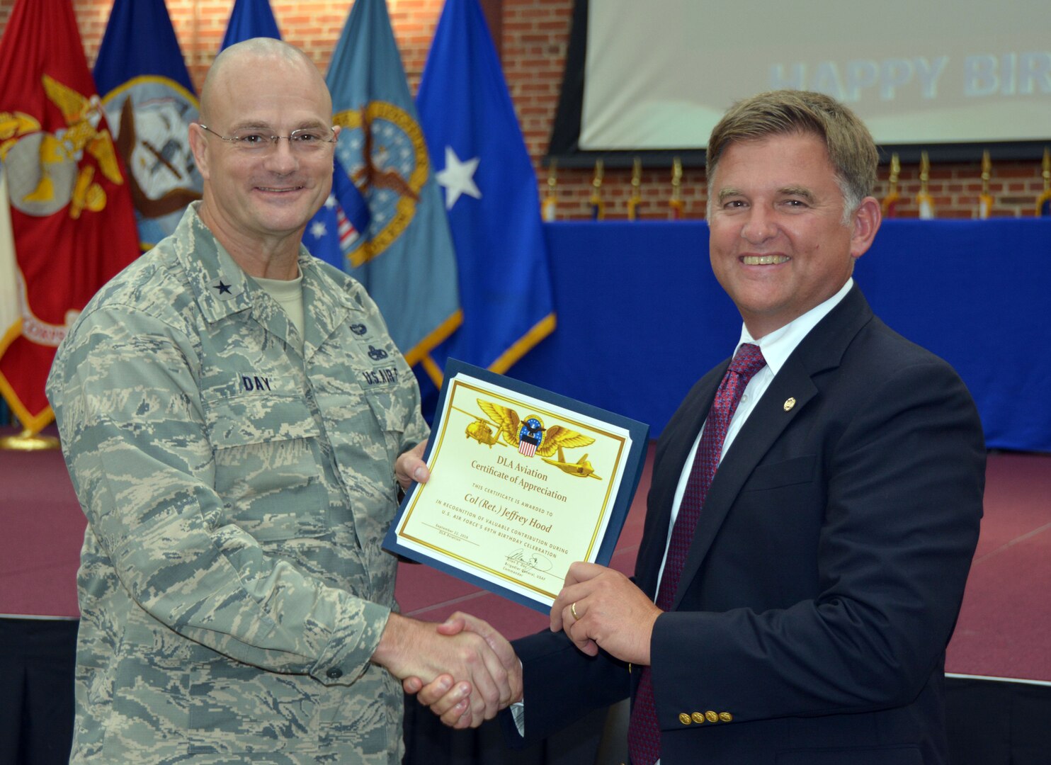 Defense Logistics Agency Aviation Commander Air Force Brig. Gen. Allan Day presents a certificate of appreciation to retired Air Force Col. Jeffrey Hood during the Air Force’s 69th birthday ceremony held at the Lotts Center on Defense Supply Center Richmond, Virginia, Sept. 22, 2016. Hood, a former pilot, served in the Air Force from 1986 until 2014. He was one of two guest speakers during the ceremony. 
