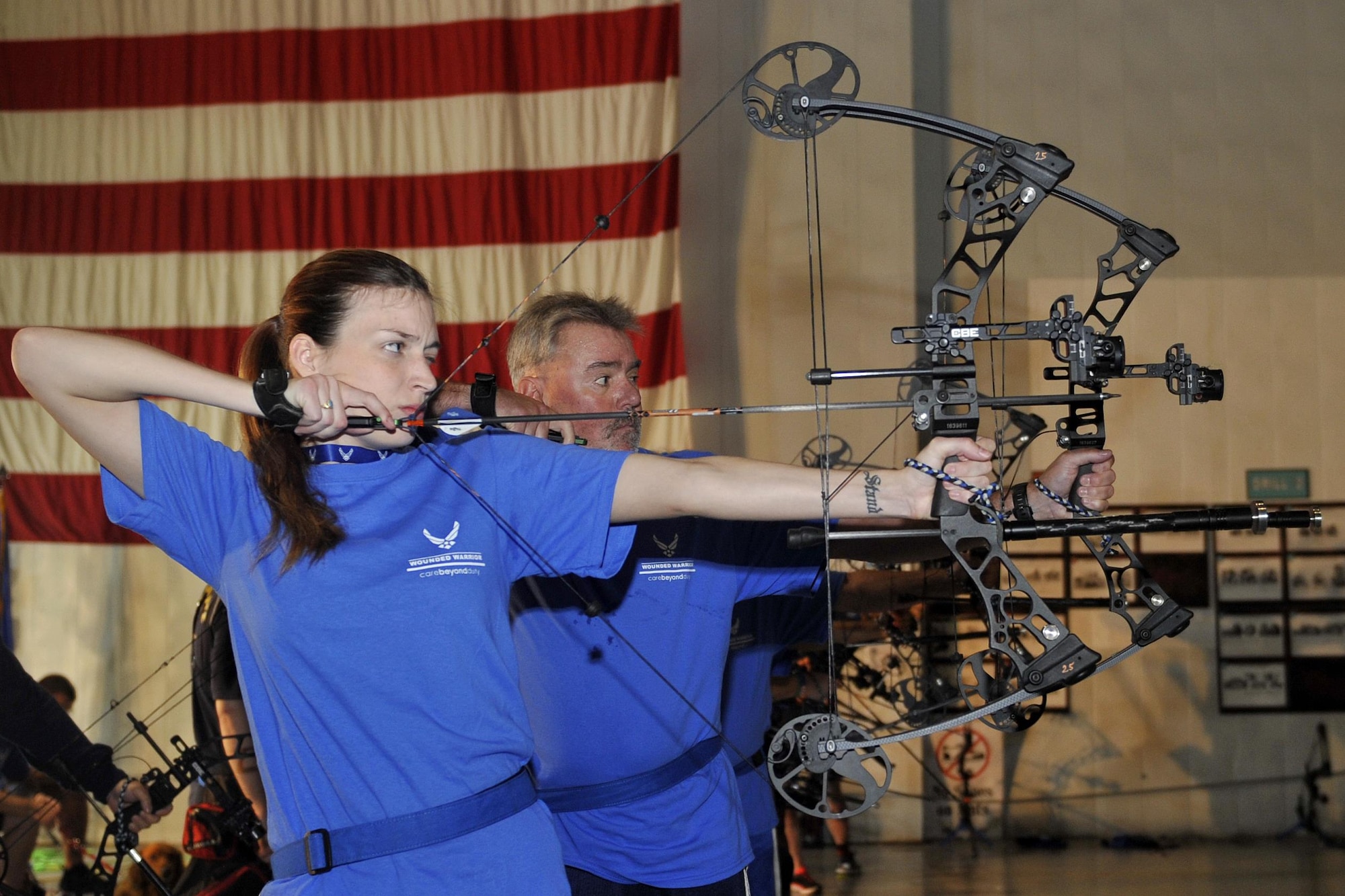 U.S. Air Force Senior Airman, KeiLani Vessar, 55th Medical Operations Squadron, and U.S. Air Force (retired) Pete Plaza, take aim with their bows during an archery exercise. Wounded warriors members from across the country participated in a special camp focused on recovery. More than 120 participated in hopes to aid with their healing process with events like archery, swimming, basketball and more at Offutt Air Force Base, Nebraska, Sept. 17 - 23. (U.S. Air Force photo by Jeff W. Gates)