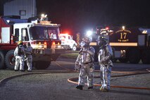 788th Civil Engineer Squadron firefighters converse after putting out an internal aircraft fuselage fire during a training exercise at their burn pit, Sept. 19, 2016 at Wright-Patterson Air Force Base, Ohio. Aircraft fire training is conducted routinely throughout the year to ensure crews are ready should the need ever arise. (U.S. Air Force photo by Wesley Farnsworth)