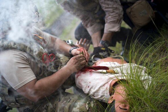 U.S. Air Force Senior Airman Michael Triana, left, 347th Operations Support Squadron independent duty medical technician-paramedic, addresses injuries on a simulated patient during a tactical combat casualty care course, Sept. 22, 2016, in Okeechobee, Fla. TCCC tests and reinforces participants’ lifesaving medical skills while they are in high-stress, combat scenarios. (U.S. Air Force photo by Staff Sgt. Ryan Callaghan)