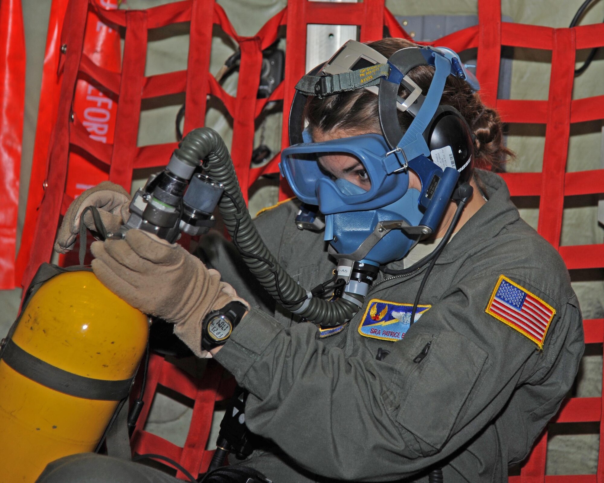 Senior Airman Patrice Barnett, 45 Aeromedical Evacuation Squadron, MacDill AFB, Florida, dons her oxygen mask during a simulated inflight emergency.  Recently the 45 AES teamed up with the 302 Airlift Wing, Peterson AFB, Colorado for a three-day training mission. (U.S. Air Force photo by Tech. Sgt. Peter Dean)