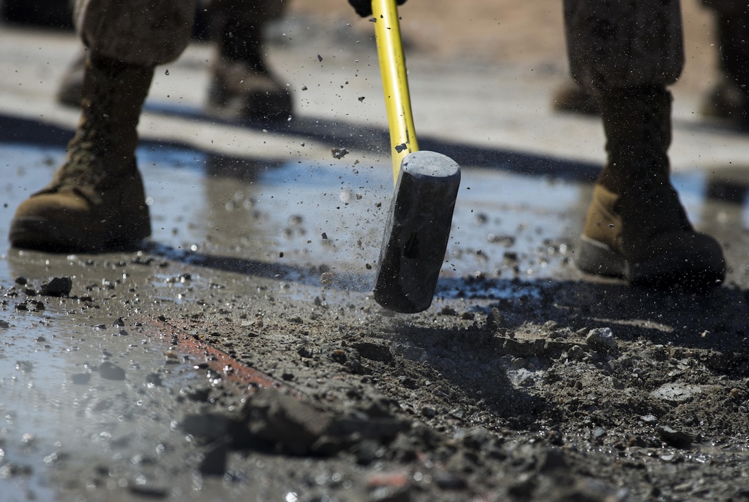 U.S. Marine Corps Master Sgt. Anthony Goodwater, a combat engineer with Marine Wing Support Detachment 31 breaks down concrete using a sledgehammer as part of an airfield damage repair practical application exercise during Weapons and Tactics Instructors course 1-17 at Cannon Air Defense Complex Yuma, Ariz., Sept. 24, 2016. WTI is a seven week training event hosted by MAWTS-1 cadre which emphasizes operational integration of the six functions of Marine Corps aviation in support of a Marine Air Ground Task Force. MAWTS-1 provides standardized advanced tactical training and certification of unit instructor qualifications to support Marine aviation Training and Readiness and assists in developing and employing aviation weapons and tactics. 