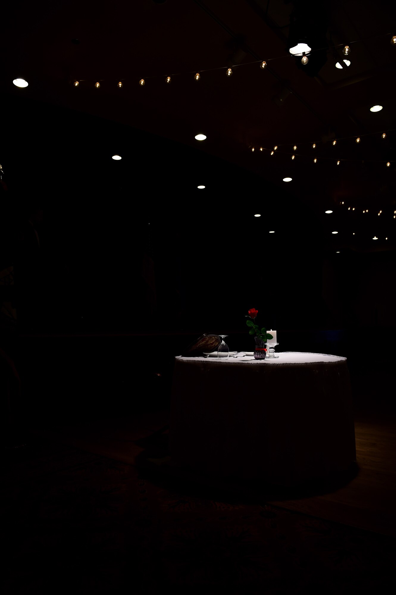 The POW/MIA table is displayed in a solitary light during a senior NCO induction ceremony Sept. 23, 2016, Heritage Eagle Bend Golf Course in Aurora, Colo. The POW/MIA table reminded those who saw it of the prisoners of war or missing in action.  (U.S. Air Force photo by Airman 1st Class Gabrielle Spradling/Released)