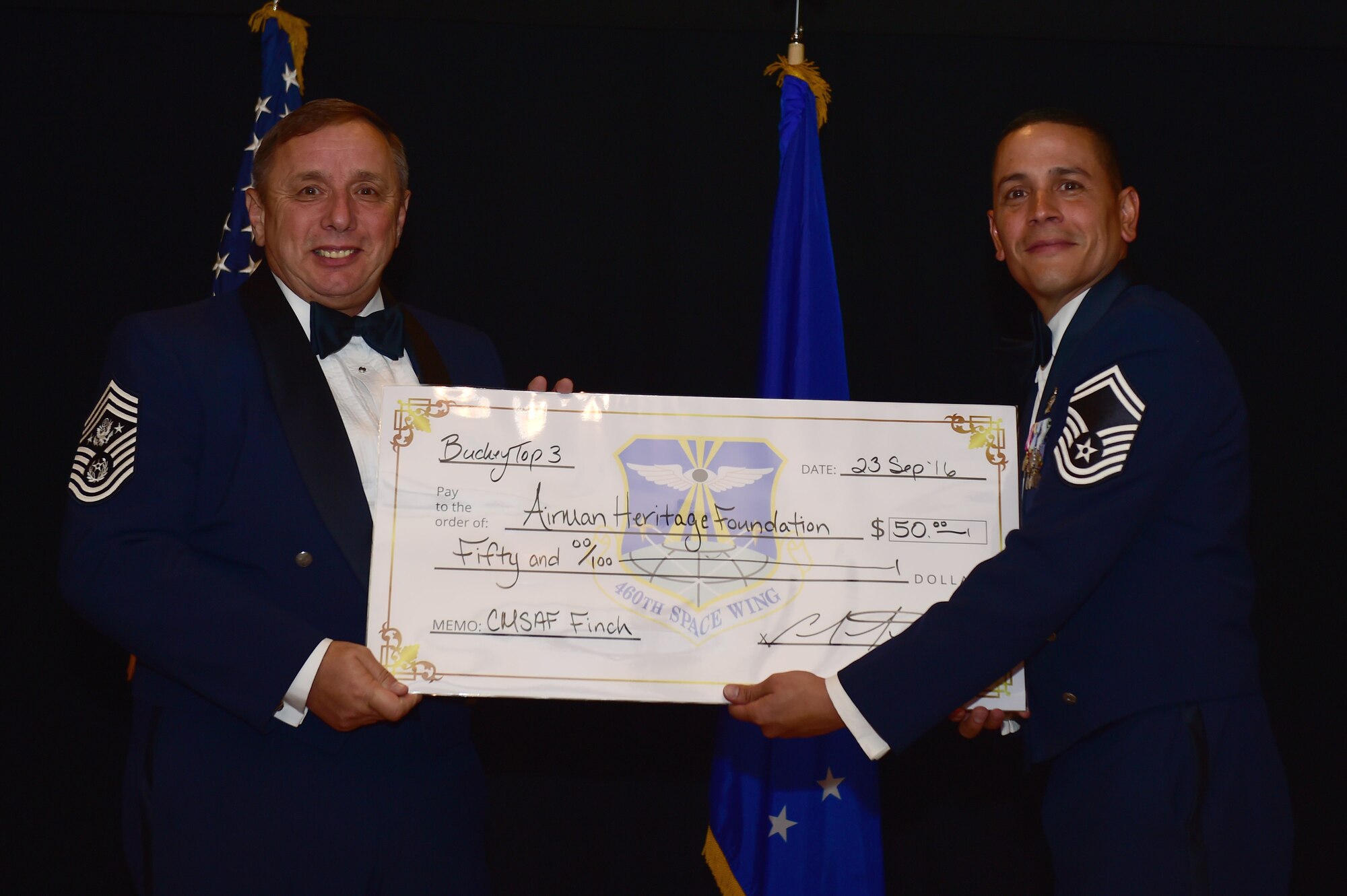 Former Chief Master Sgt. of the Air Force Frederick J. "Jim" Finch receives a check on behalf of the Airmen Heritage Foundation from Senior Master Sgt. Carlos Martinez, 2nd Space Warning Squadron director of staff, during a senior NCO induction ceremony Sept. 23, 2016, Heritage Eagle Bend Golf Course in Aurora, Colo. The Airmen Heritage Fund provides support to the U.S. Air Force Airmen Heritage Museum, Enlisted Character Development Center and other heritage-related activities in hopes of preserving and honoring the history and heritage of enlisted Airmen. (U.S. Air Force photo by Airman 1st Class Gabrielle Spradling/Released)