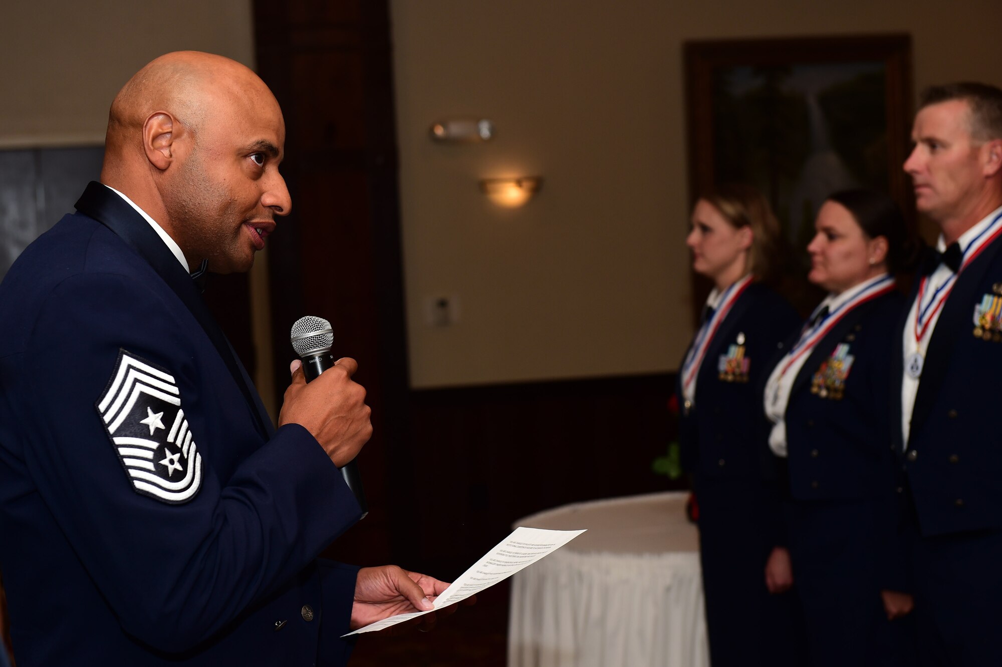 Chief Master Sgt. Rod Lindsey, 460th Space Wing command chief, reads the senior NCO charge during an induction ceremony Sept. 23, 2016 Heritage Eagle Bend Golf Course in Aurora, Colo. The charge provided an outline of what SNCO’s are responsible for doing, including helping leaders make informed decisions, be an active and visible leader, and to promote responsible behaviors within all Airmen. (U.S. Air Force photo by Airman 1st Class Gabrielle Spradling/Released)