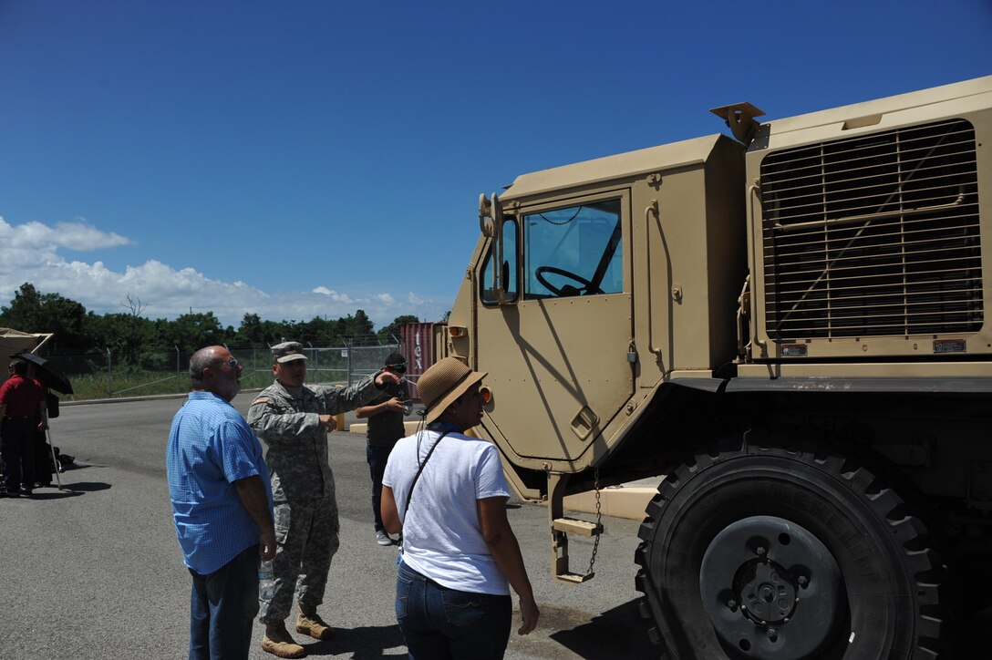 Sgt. Nathaniel Rivera informs his mother-in-law and father-in-law of the purpose of the vehicles on exhibit after the 246th Quartermaster Co. (MA) farewell ceremony at the Army Reserve Center at Mayaguez, PR.