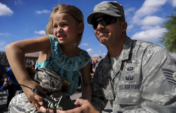 Senior Airman Michael Buras’s daughter, Maddison, detonates a first blast at the new Buras EOD Facility on Nellis Air Force Base, Nev., Sept. 21. Buras continued to serve after being awarded the Purple Heart, and deployed in support of ongoing wartime operations. (U.S. Air Force photo by Airman 1st Class Kevin Tanenbaum/Released)