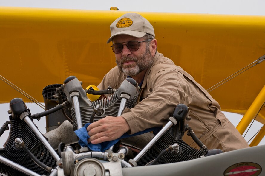 Max Langham wipes oil off the engine of a 1943 Stearman N32127 biplane at the 2016 Arkansas Military Expo at Little Rock Air Force Base, Ark., Sept. 17, 2016. This type of aircraft served as the primary trainer for U.S. Navy pilots during World War II. Utilized as crop duster for years after the war, this particular aircraft was totally restored in 1985, by Pete Jones in Cleveland, Miss. (U.S. Air Force photo by Master Sgt. Jeff Walston/Released)