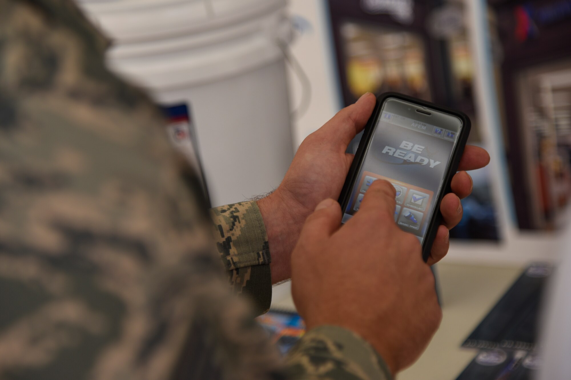 Staff Sgt. Shaun Ouellette, 11th Civil Engineering Squadron readiness and emergency manager, displays the features of the Air Force “Be Ready” app to an installation member in the Base Exchange at JBA, Md., Sept. 23, 2016. Ouellette arranged an educational booth for National Preparedness Month to teach JBA members on ways to be prepared for real world disasters. The “Be Ready” app is the mobile version of the Air Force Emergency Preparedness Guide. (U.S. Air Force photo by Airman 1st Class Valentina Lopez)