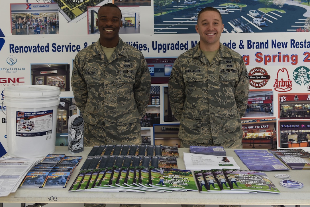 Airman 1st Class Donnie Hamilton, left, and Staff Sgt. Shaun Ouellette, 11th Civil Engineering Squadron readiness and emergency managers, stand at the information booth for National Preparedness Month in the Base Exchange at Joint Base Andrews, Md., Sept. 23, 2016.  National Preparedness Month provides a chance for readiness and emergency managers to reach out to the community and inform them of actions to take in a natural disaster, active shooter or terrorist attack. Hamilton and Ouellette had many educational guides consisting of magnets, booklets and children’s activity books to hand out to JBA members. (U.S. Air Force photo by Airman 1st Class Valentina Lopez)