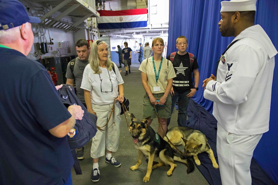 Navy Petty Officer 2nd Class Erik Bryant provides information as a tour guide for members of the Seeing Eye Puppy Training Program aboard the amphibious assault ship USS Bataan during a ship tour in New York City, May 26, 2016. Navy photo by Petty Officer 1st Class Amanda Dunford