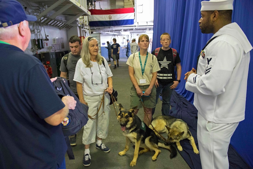 Navy Petty Officer 2nd Class Erik Bryant provides information as a tour guide for members of the Seeing Eye Puppy Training Program.