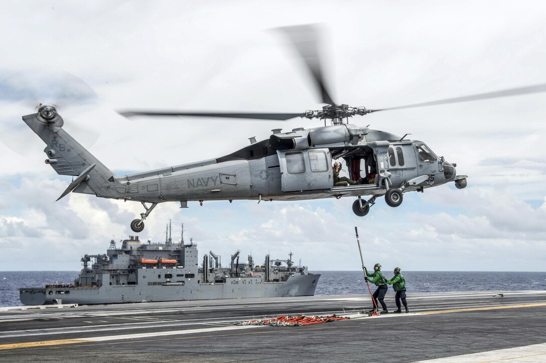 Sailors attach cargo pendants to an MH-60S Seahawk helicopter on the USS Ronald Reagan during a vertical replenishment with the Military Sealift Command dry cargo and ammunition ship USNS Charles Drew in the Philippine Sea, Sept. 23, 2016. The Reagan is participating in Exercise Valiant Shield 2016, which focuses on integrating joint training among U.S. forces. Navy photo by Petty Officer 3rd Class Nathan Burke