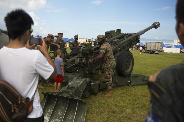 Marines give a mock demonstration of the operations of an 155 mm. artillery piece during the 22nd Annual Camp Hansen Festival Sept. 3 aboard Camp Hansen, Okinawa, Japan. The annual festival is one of the quarterly open-gate events hosted by Camp Hansen that bridges the gap between Status of Forces Agreement personnel and Okinawa residents. More than 12,855 attendees came together during the two-day event to enjoy a vast array of ethnic foods, ride carnival rides, play games for prizes and rock out to a free concert by the headlining band, American Authors. The Marines are with 1st Battalion, 10th Marine Regiment; currently assigned to 12th Marine Regiment, 3rd Marine Division, III Marine Expeditionary Force, under the unit deployment program.