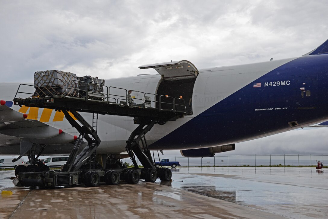 Airmen from the 734th Air Mobility Squadron unload a Boeing 747 onto a Tunner 60K aircraft cargo loader Sept. 7, 2016, at Andersen Air Force Base, Guam. The Tunner 60K aircraft cargo loader is capable of transporting up to six cargo pallets at a maximum speed of 23 mph. The vehicles deck elevates from 39 inches to 18 feet 6 inches high and employs a powered conveyor system to move cargo. (U.S. Air Force photo by Airman 1st Class Jacob Skovo)