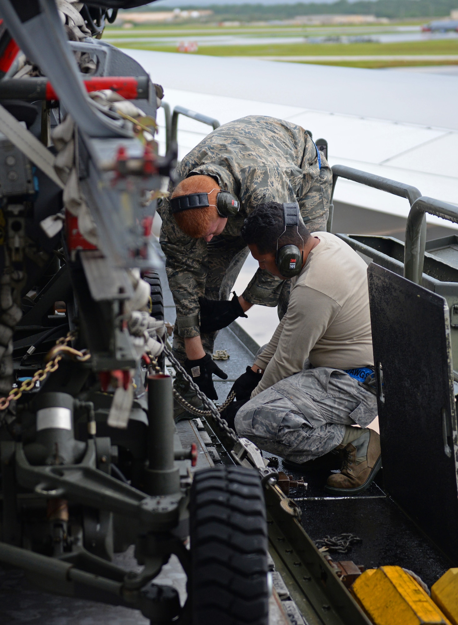 Staff Sgt. Vincent Lim, 734th Aircraft Mobility Squadron load team chief, and Airman Zachary Puerner, left, 734th AMS aircraft services technician, tie down cargo on a Tunner 60K aircraft cargo loader Sept. 7, 2016, at Andersen Air Force Base, Guam. The 734th AMS provides the capability to move cargo, personnel and equipment at a high velocity, ensuring Andersen AFB is prepared to meet mission requirements.(U.S. Air Force photo by Airman 1st Class Jacob Skovo)
