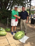 Joe Miller, a Subsistence field rep, stands with the Kentucky Commissioner of Agriculture after his watermelon earned second place at the Kentucky State Fair in August. Miller uses his produce expertise to support DLA Troop Support customers. 