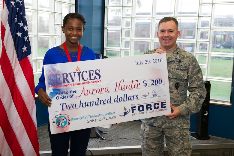 Col. Z. Walter Jackim, 45th Space Wing vice commander, (right), presents Aurora Hunter, with an award for placing second in the solo act preteen category for the 2016 Operations Talent Search at Patrick Air Force Base, Fla. Hunter was presented the award Sept. 21, 2106, during the Science, Technology, Engineering and Mathematics classroom opening and Worldwide Day of Play. (U.S. Air Force photo/Benjamin Thacker) 