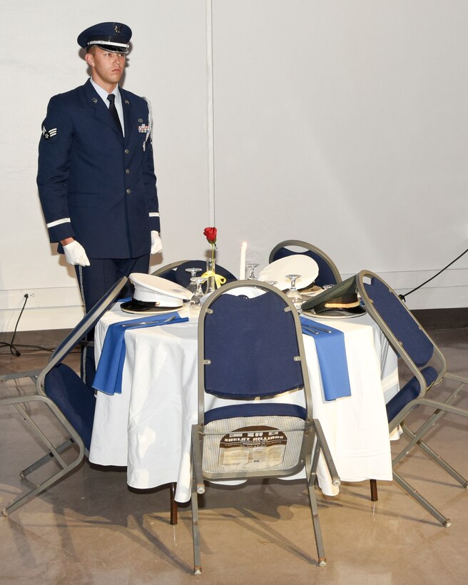 U.S. Air Force Senior Airman James Lovejoy, 7th Force Support Squadron honor guardsman, stands at attention in front of a POW/MIA table during the 2016 Air Force Ball at the Abilene Civic Center in Abilene, Texas, Sept. 23, 2016. Lovejoy performed a tribute in remembrance of missing and fallen service members. (U.S. Air Force photo by Senior Airman Kedesha Pennant)