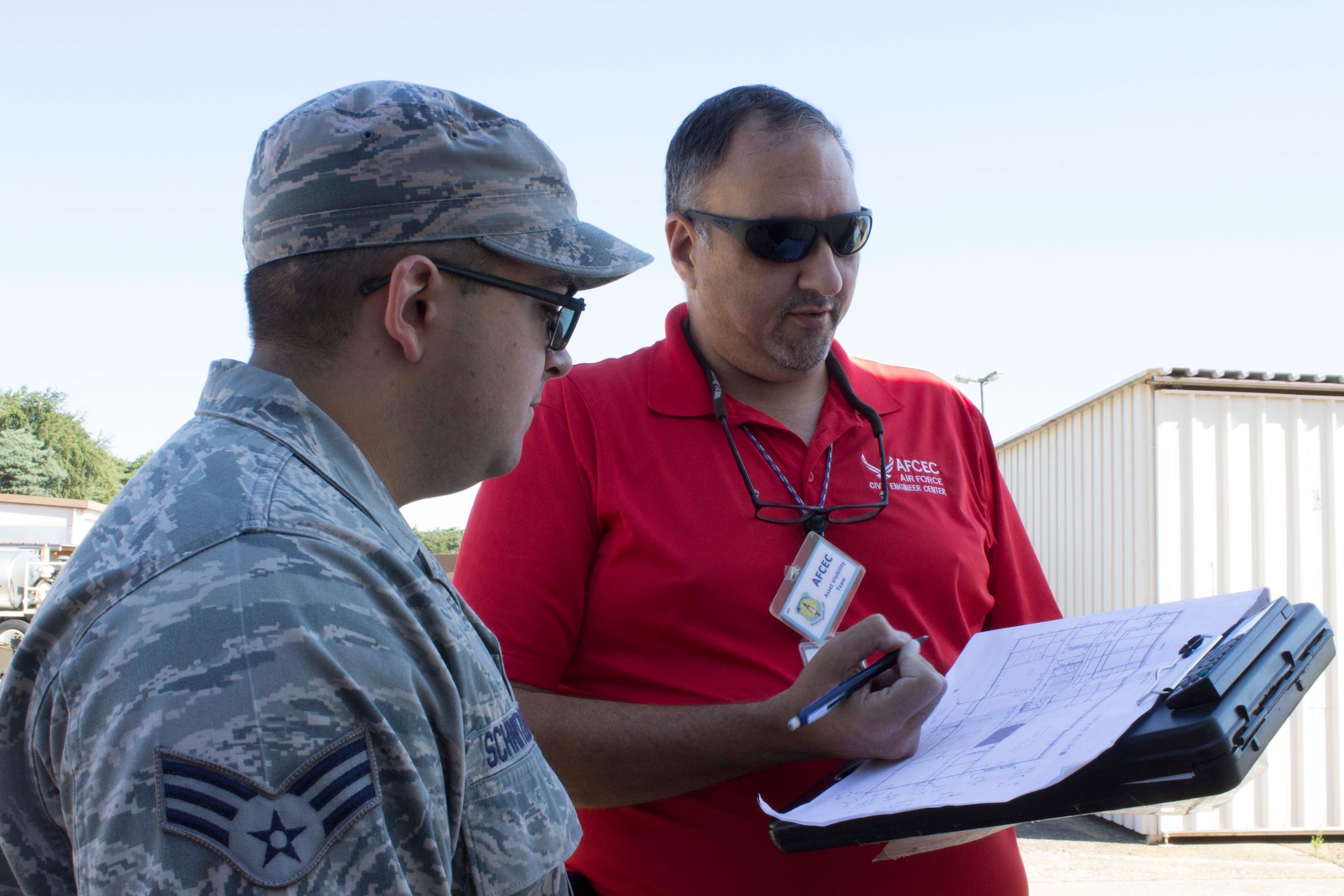 Arnaldo Vincenty points out areas of a building for assessment at Ramstein Air Base, Germany, to Senior Airman Nolan Schnitzler and confirms the layout with facility drawings. The evaluation will allow them to go into BUILDER to ensure the validity of the inventory. (U.S. Air Force Photo/Susan Lawson)

