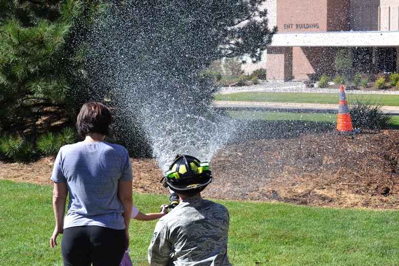 Attendees get a fire hose demonstration during Nickelodeon’s Worldwide Day of Play event held in Patriot Park, at Peterson Air Force Base, Colorado, Saturday, Sept. 24, 2016. The Peterson Fire Department was one of many agencies providing information and interactive demonstrations during the event. (U.S. Air Force photo/Brian Hagberg)